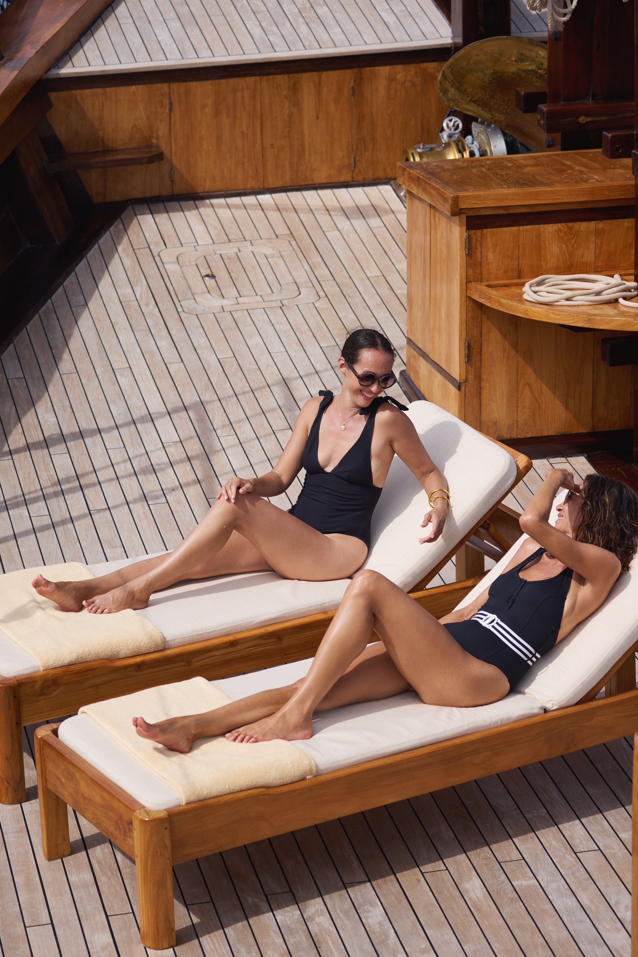 Two guests on the sunbeds, teak underfoot