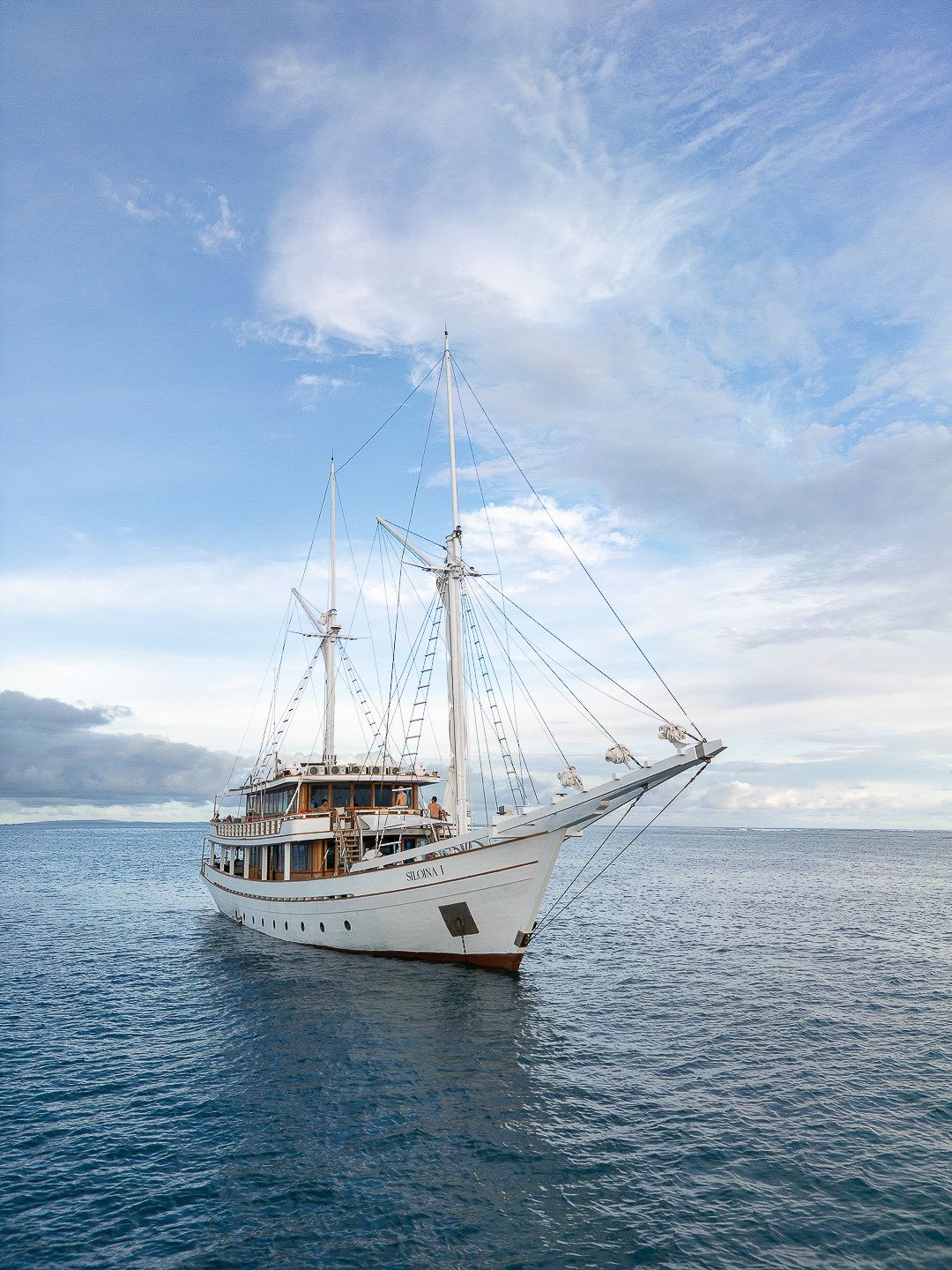 Siloina at anchor on the sea with cloud above.