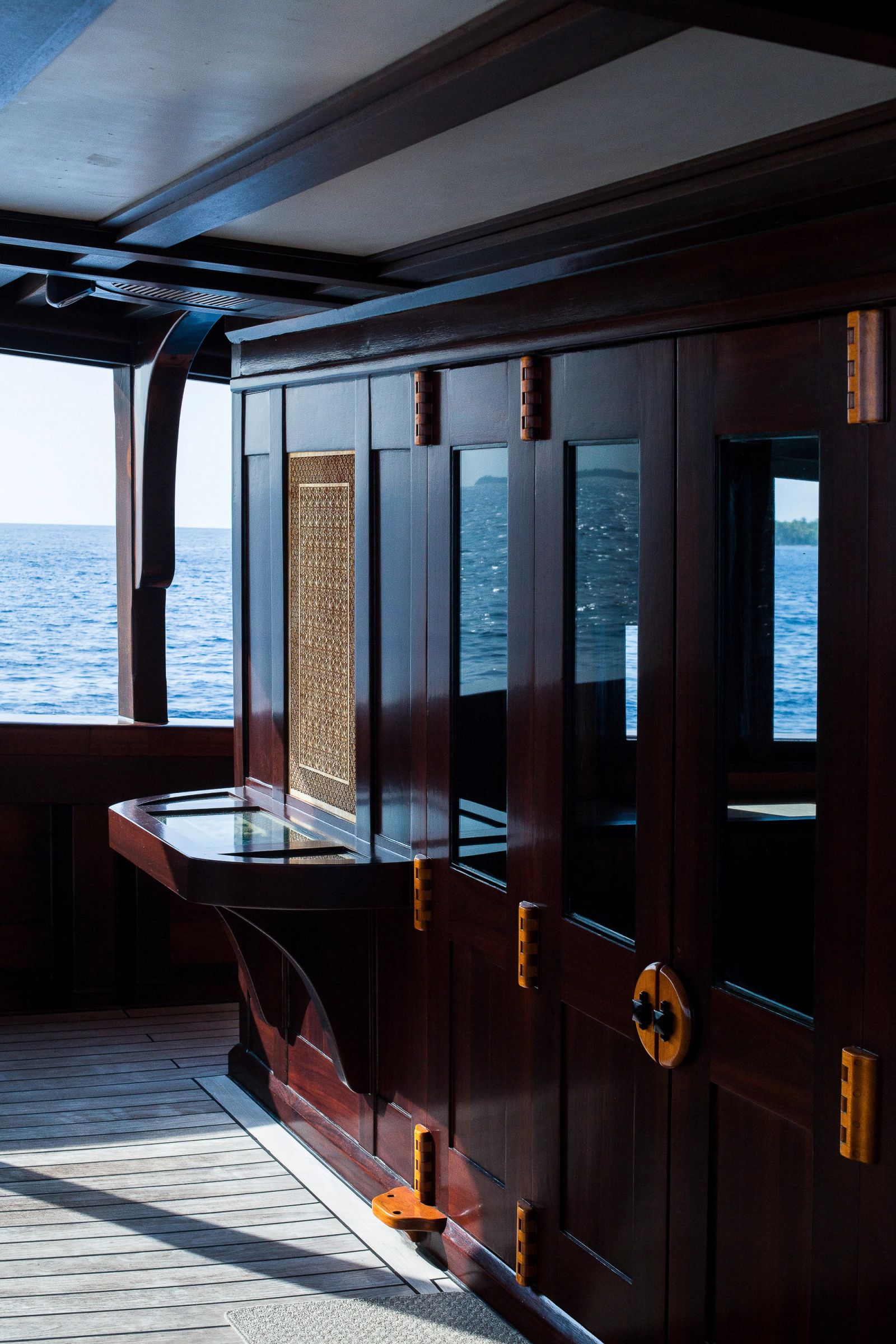 Dark timber joinery and glazed doors aboard Dunia Baru