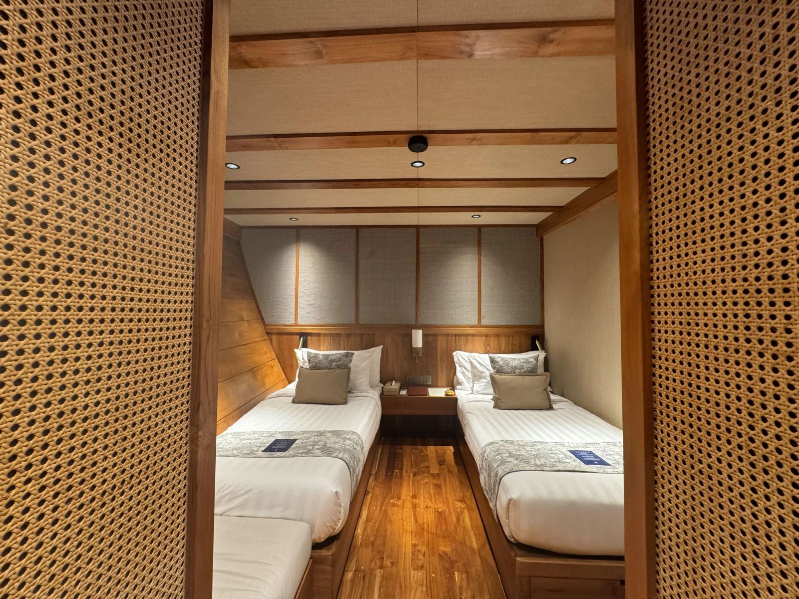 A twin stateroom on Celestia with two beds behind a carved wooden screen.