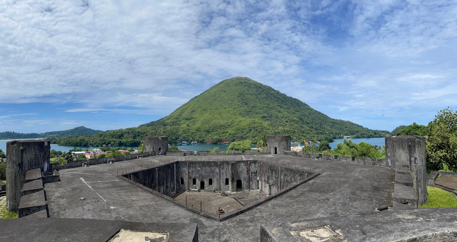 Fort Belgica's ramparts above Banda Neira, with the Gunung Api volcano beyond.