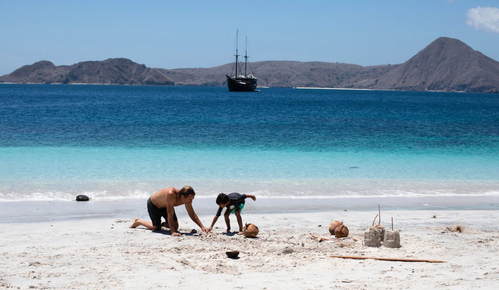 A family building a sandcastle on a quiet beach