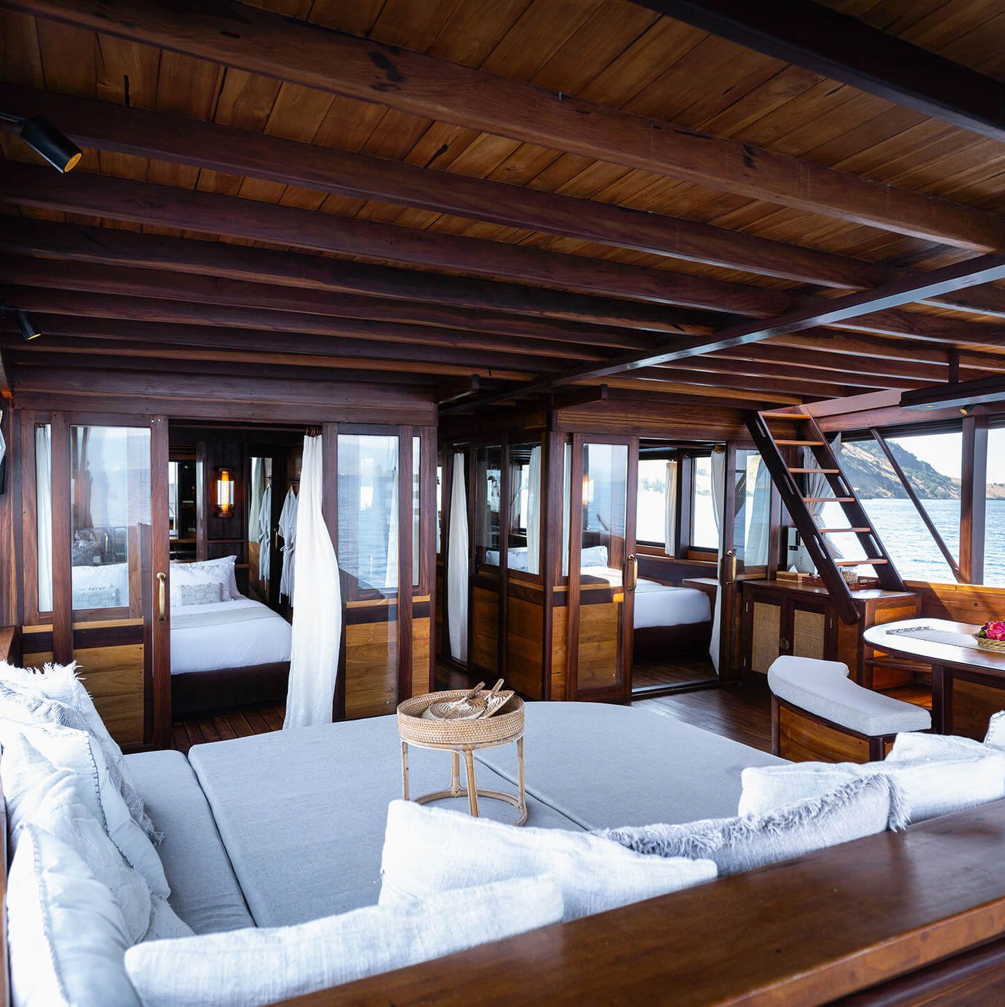 The saloon on Dewata with a sofa in the foreground and a cabin beyond.