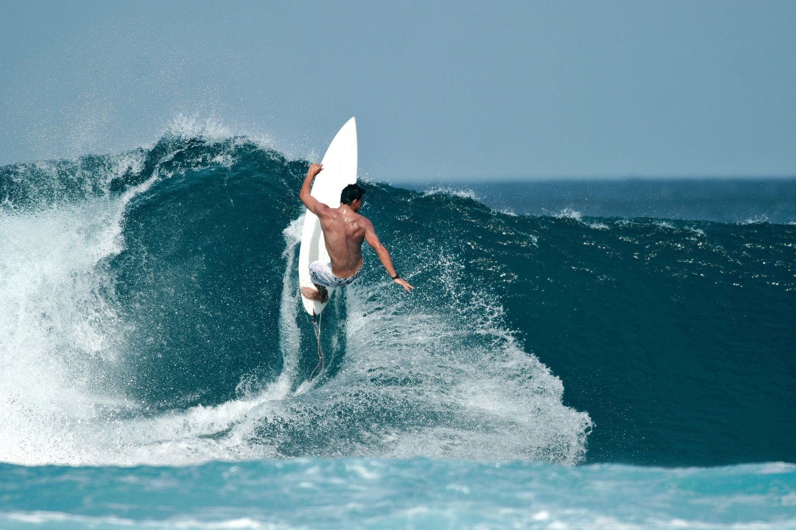 A surfer drives off the bottom of a Mentawai reef wave, carried by the swell that made these islands famous.