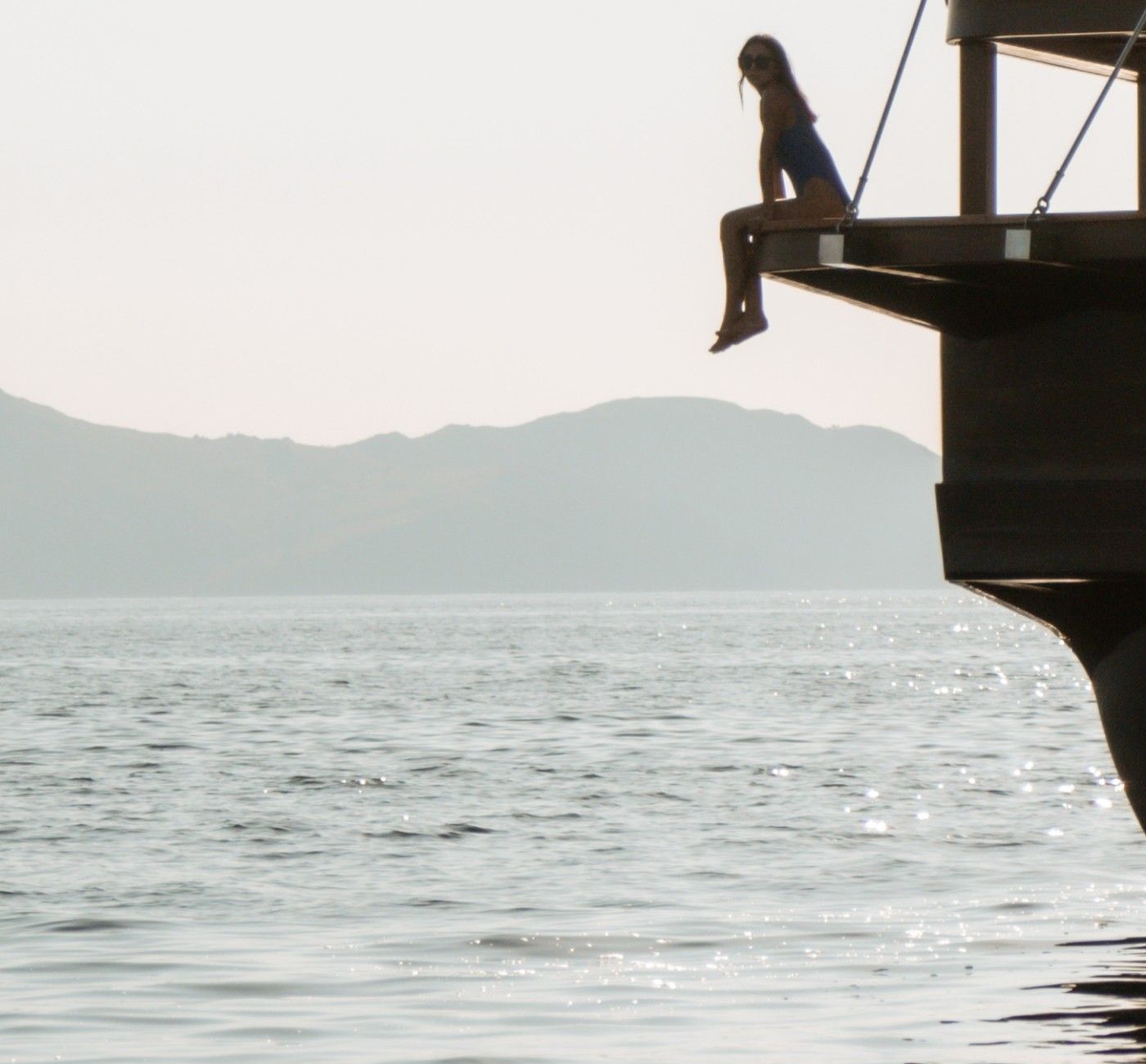 A guest sits on the edge of Celestia's swim platform