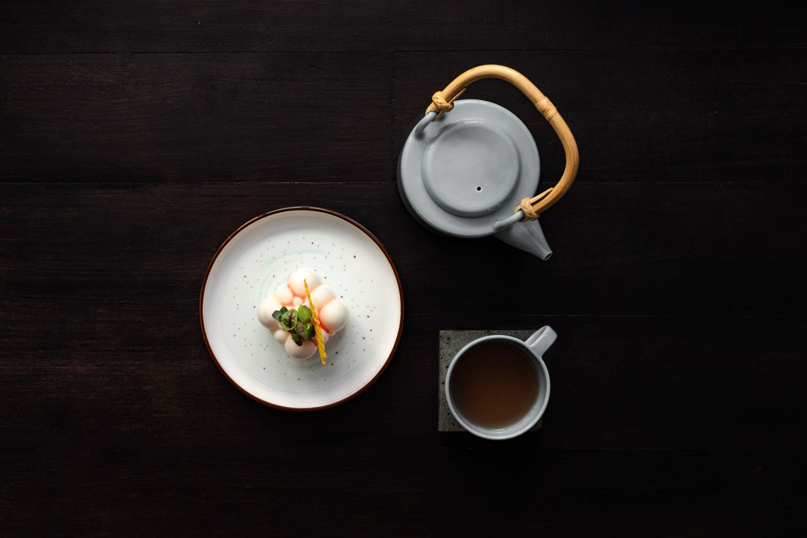 Breakfast and tea laid on dark timber aboard Vela