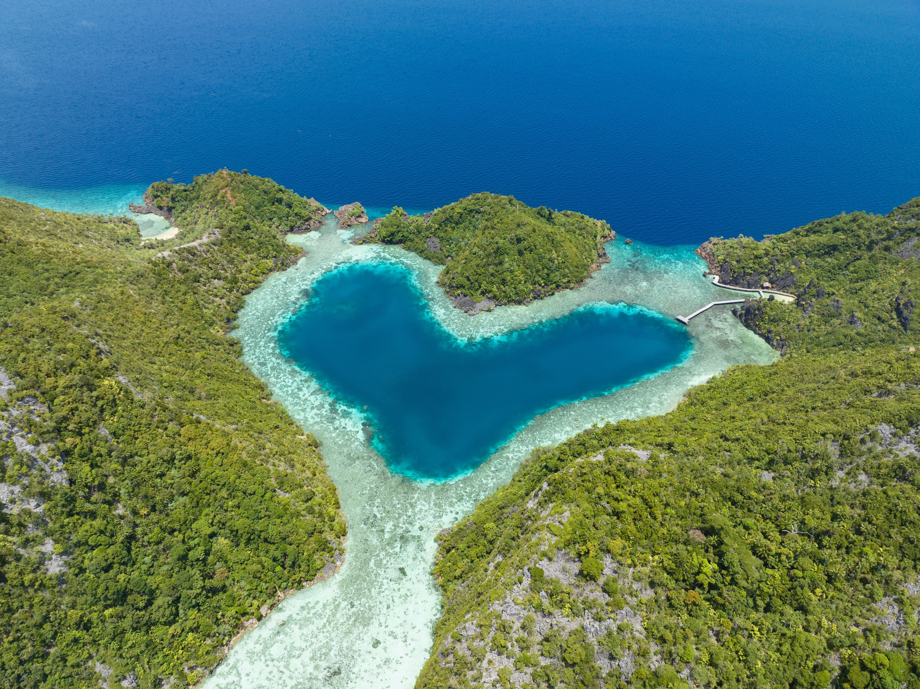 A heart-shaped lagoon is surrounded by dramatic limestone islands that rise from Raja Ampat's seascape in Misool. This remote part of Indonesia is known for its incredible marine biodiversity.