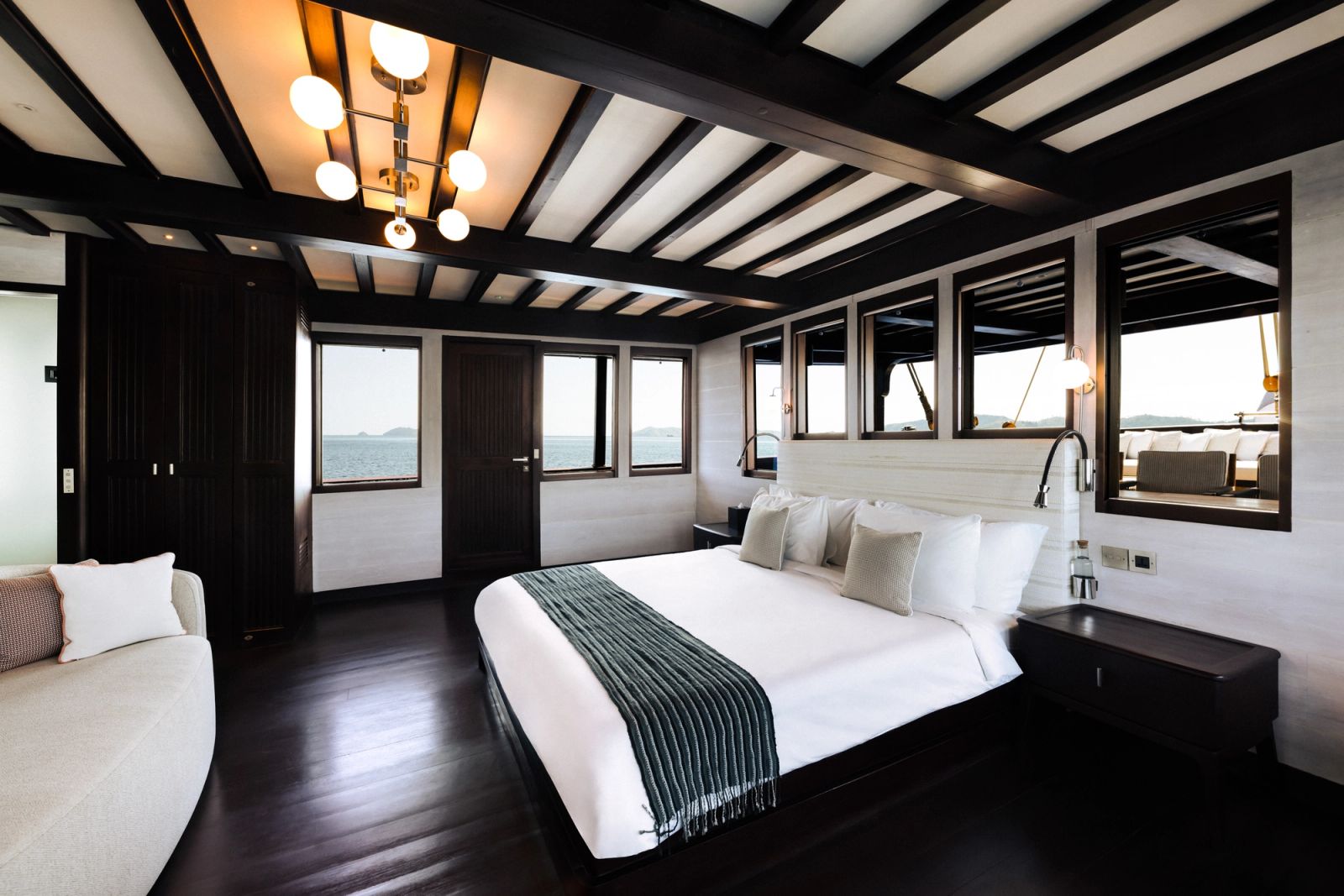 A bright guest cabin aboard Vela with dark timber floors