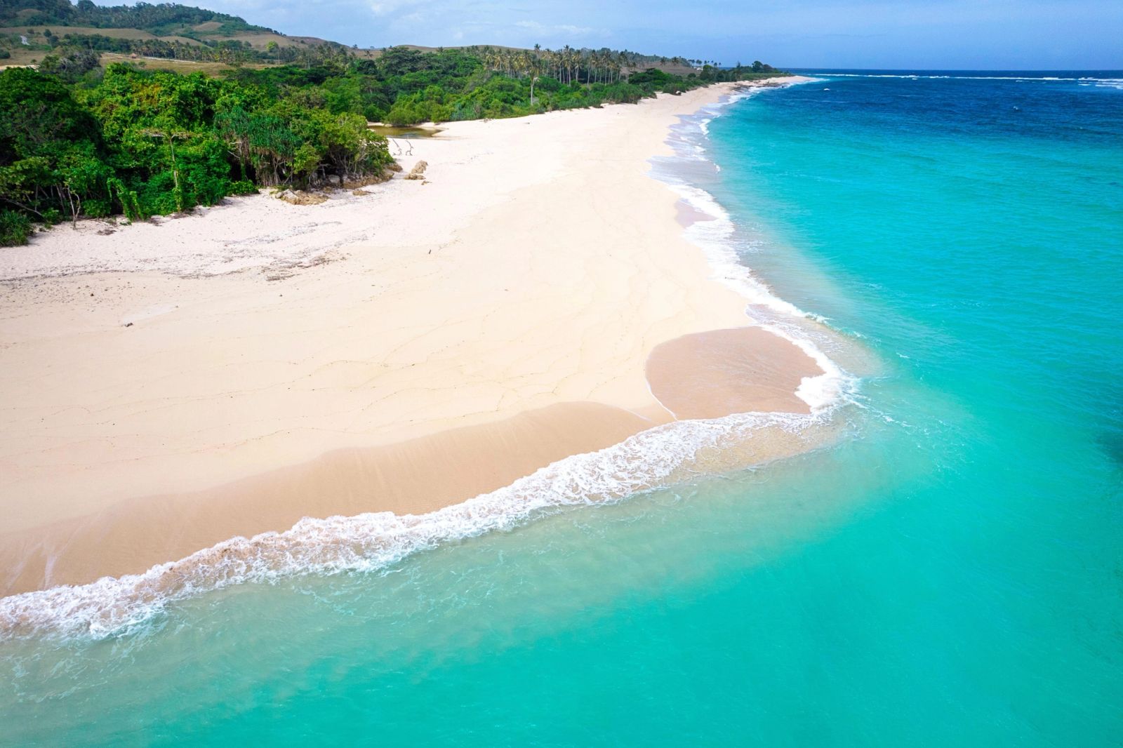 The long white curve of Marosi Beach on Sumba from the air