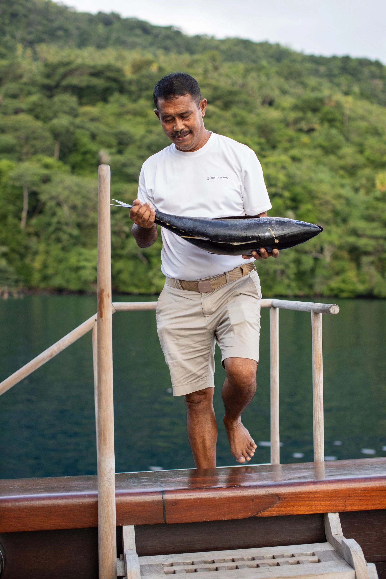 A crew member carrying a fresh fish aboard