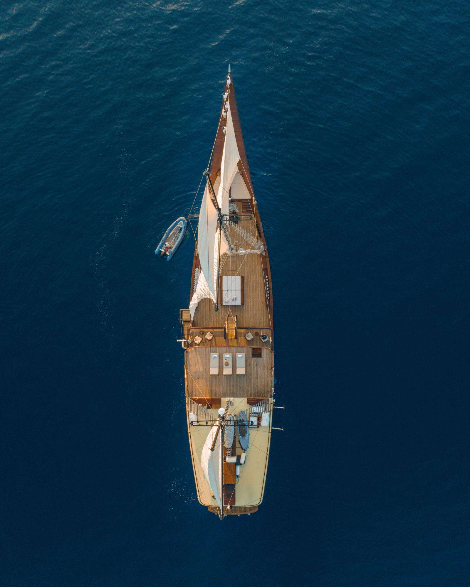 An aerial view straight down onto Celestia sailing on deep blue water.