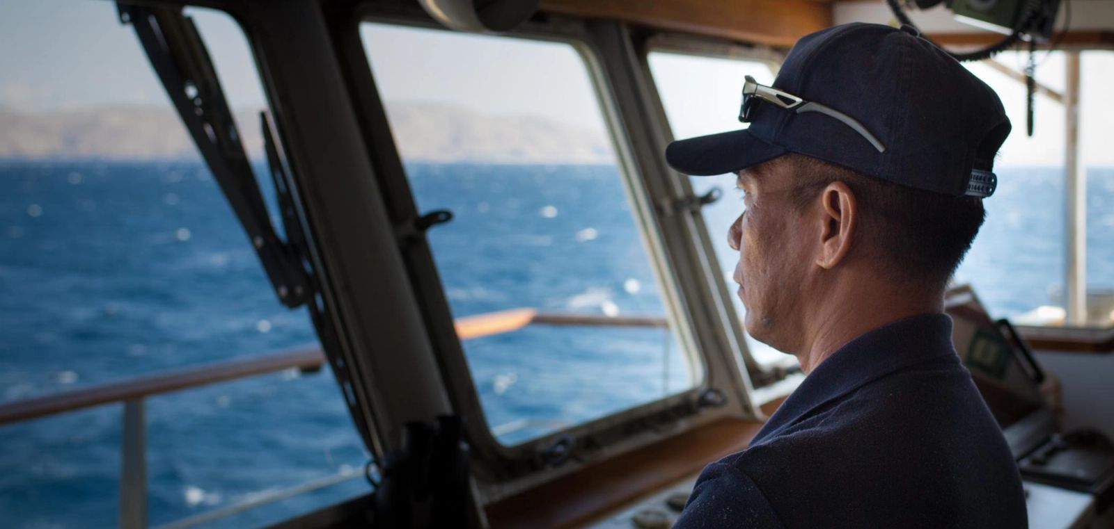 Captain Wayan observing the horizon from the bridge.