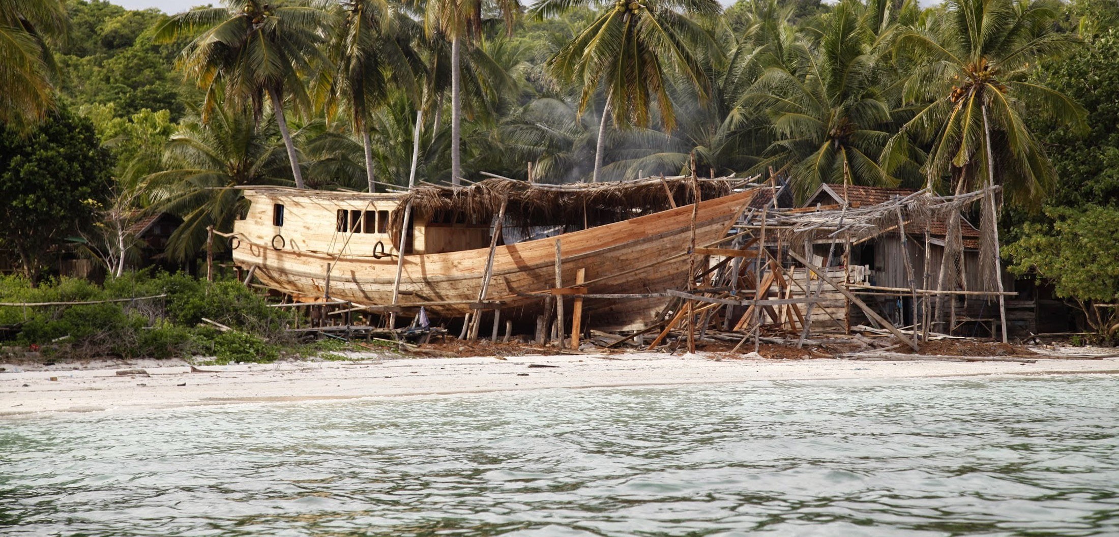 A phinisi hull taking shape on the beach at Tana Beru