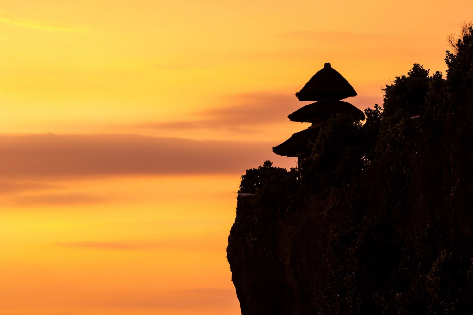 A clifftop sea temple against a Bali sunset, one of thousands on the island.