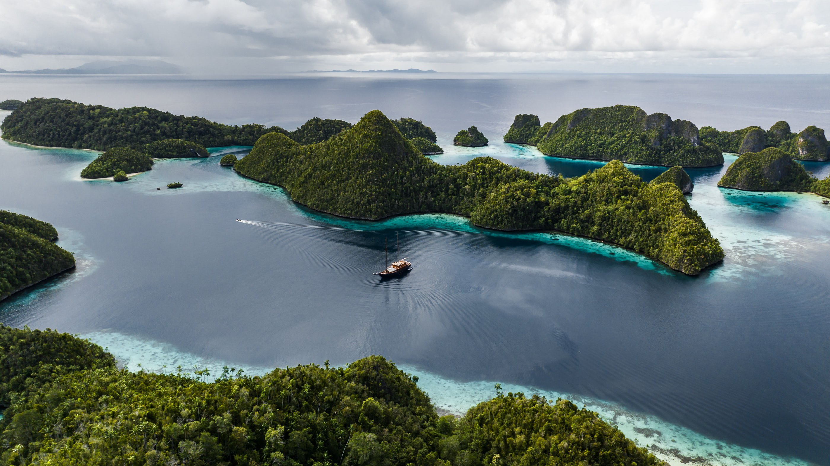 Vela at anchor in a turquoise Wayag lagoon