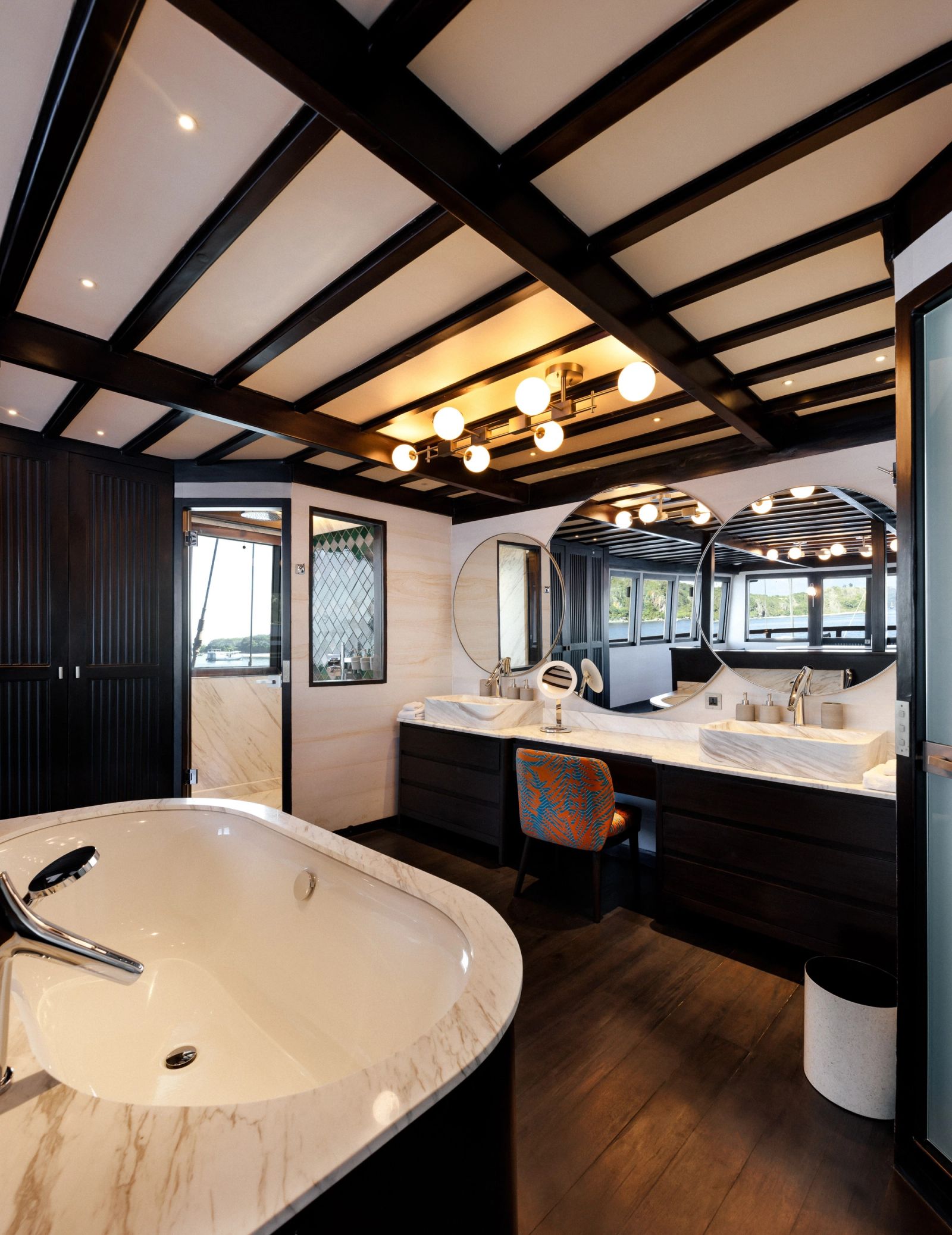 The Owner's Suite bathroom aboard Vela with bathtub and twin marble vanities