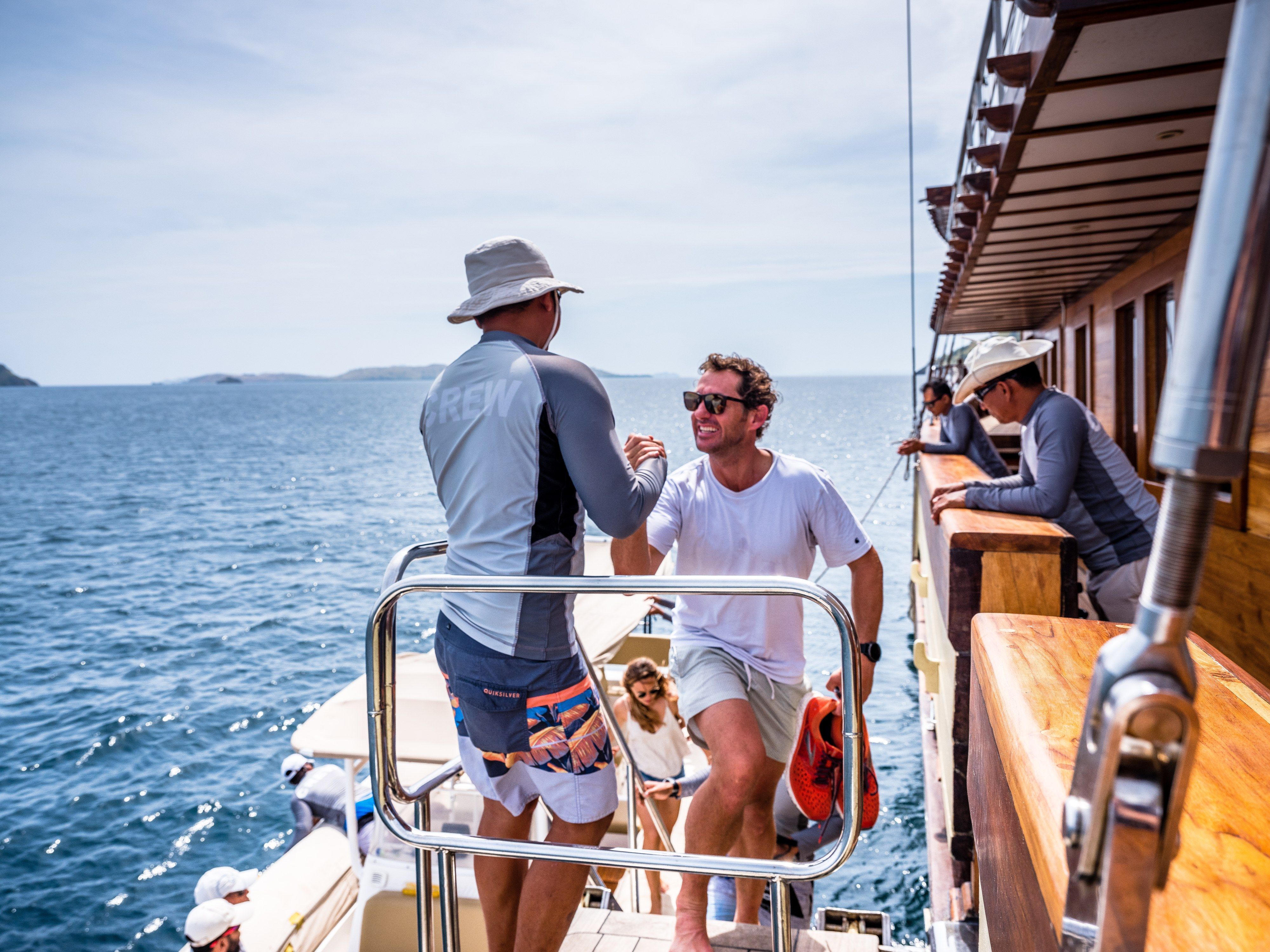 The crew help guests step aboard at the boarding ladder.