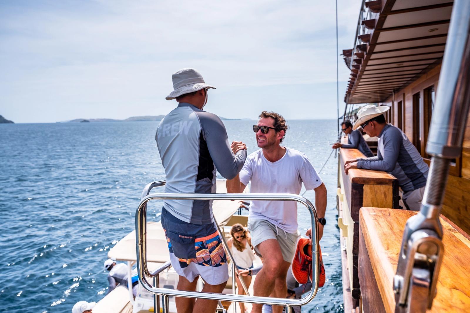 The crew help guests step aboard at the boarding ladder.