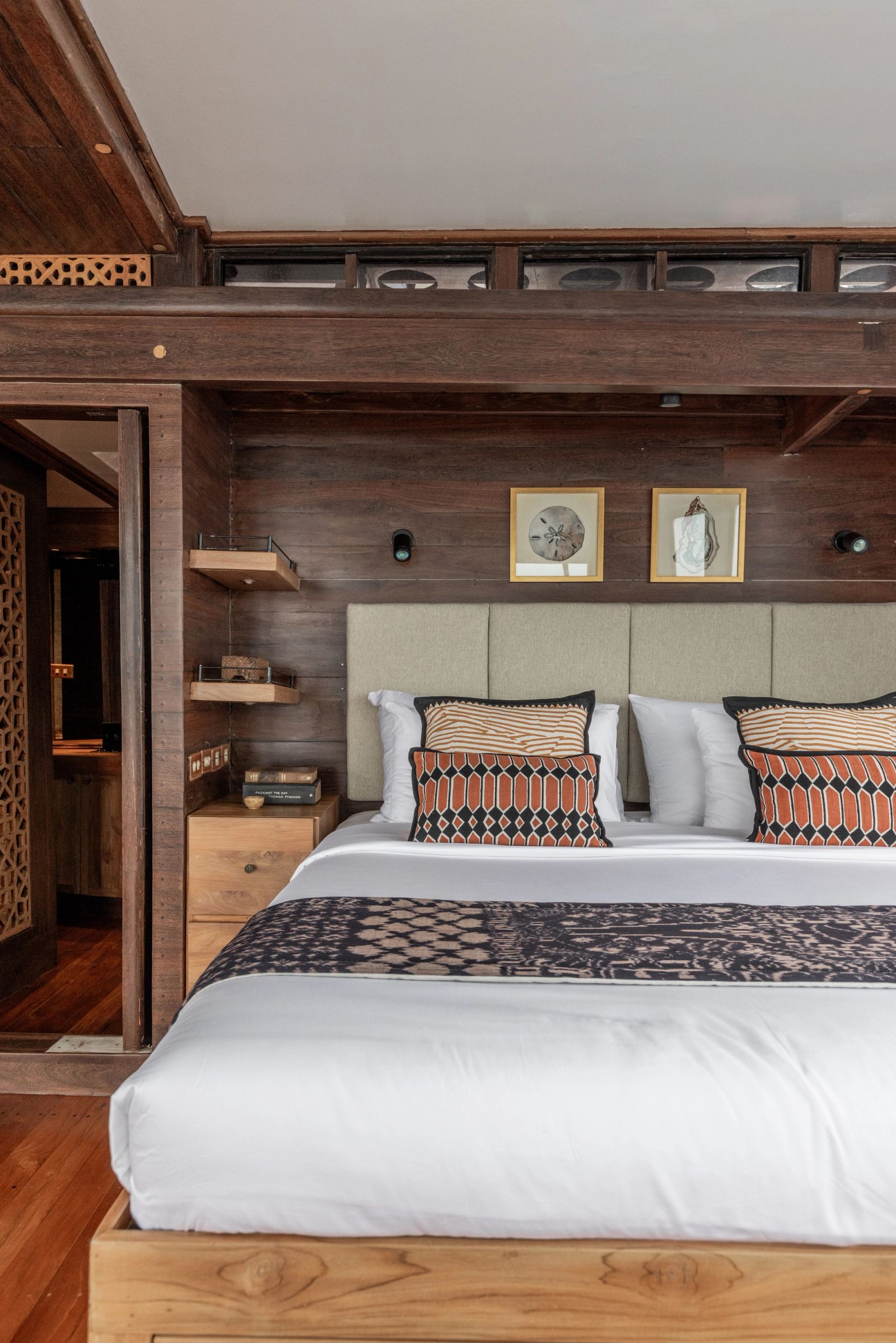 The master cabin bed on El Aleph with a headboard and a black woven runner.