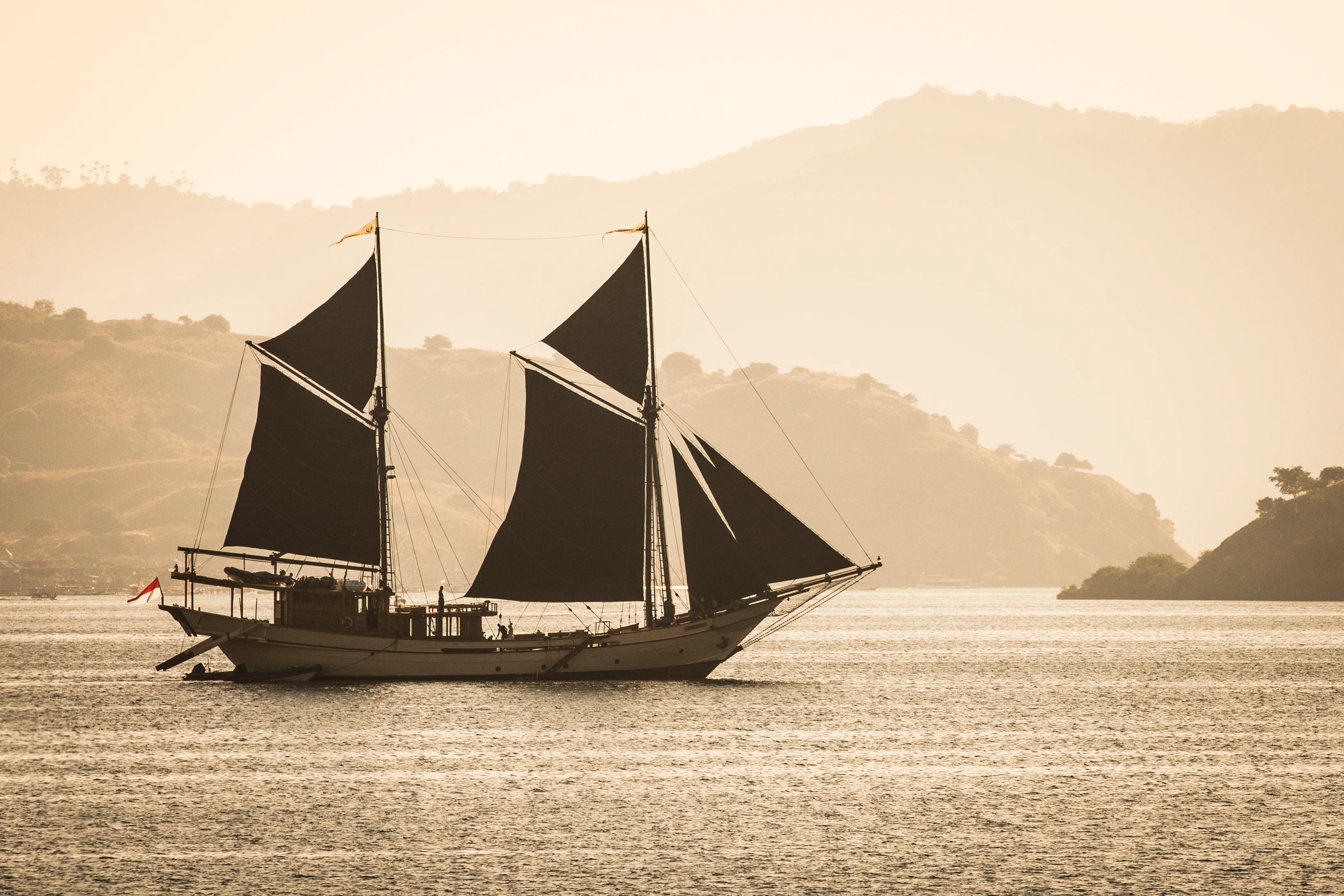 Silolona sailing into the sunset under her red sails