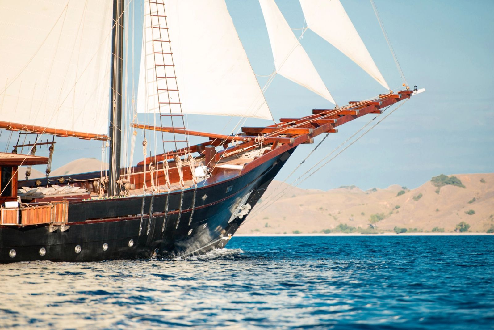 A Konjo-built two-masted phinisi under cream sails