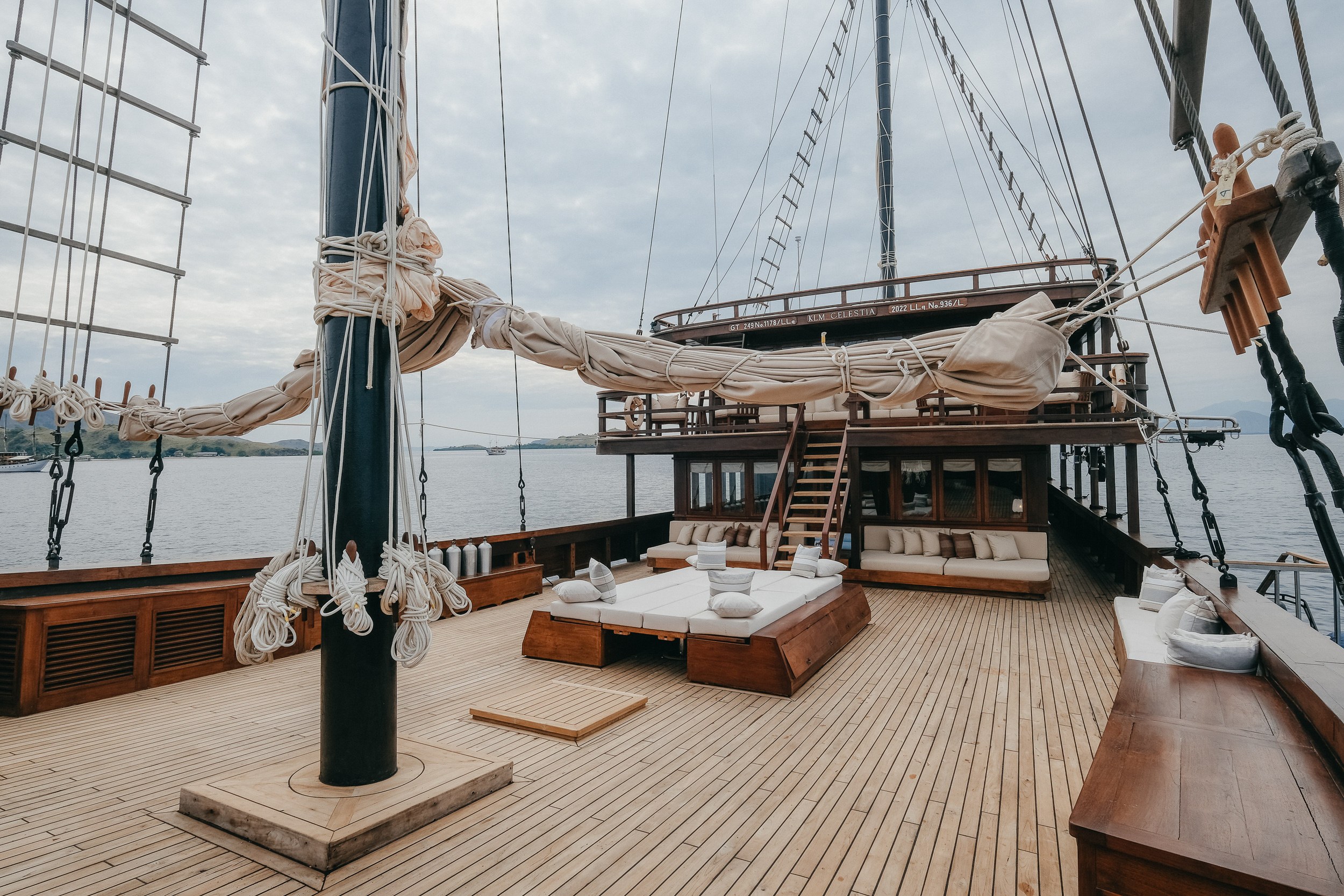 A wide view of the deck of Celestia with a daybed and the upper deck behind.
