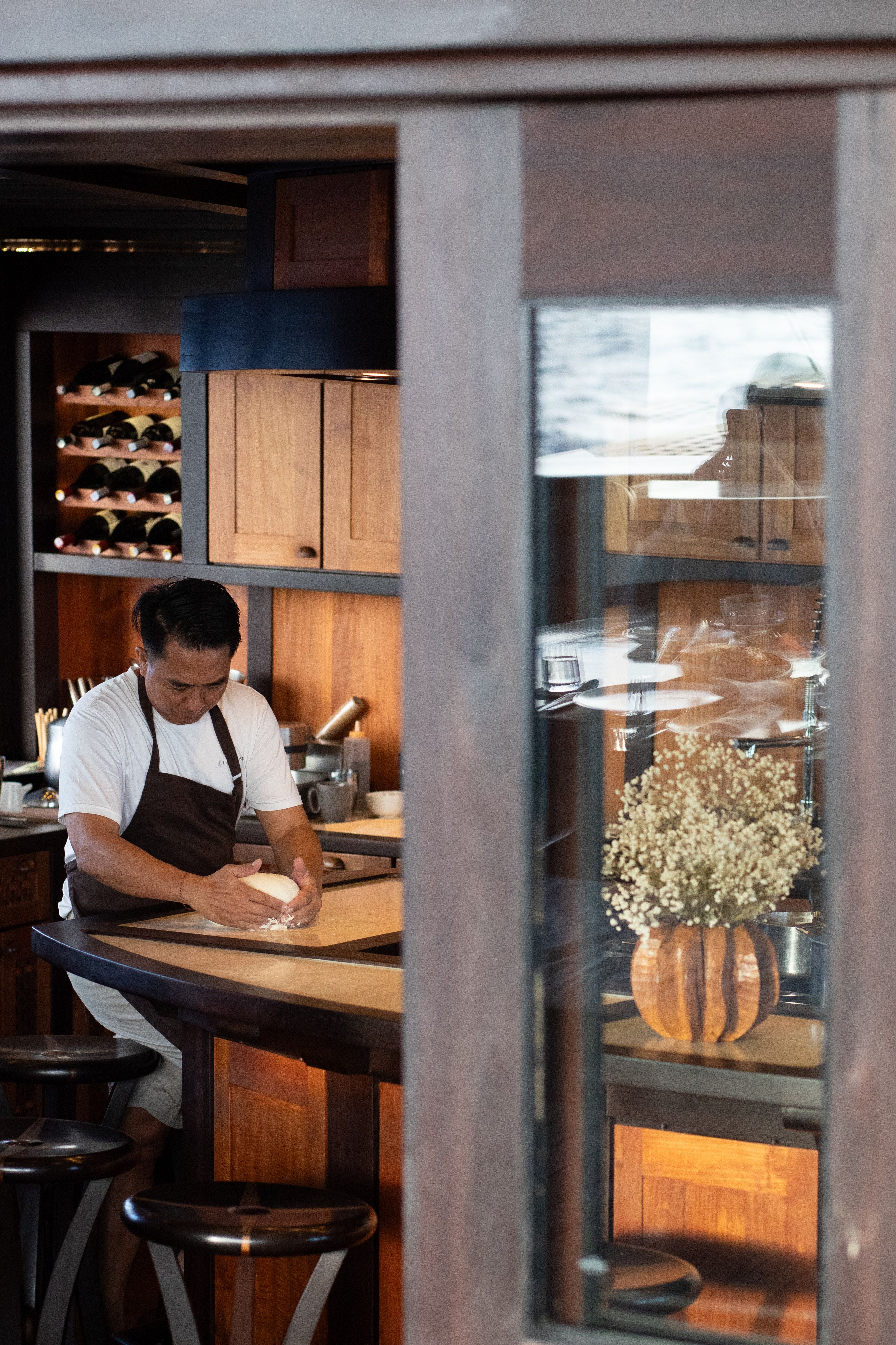The chef kneads dough at the galley counter aboard Dunia Baru