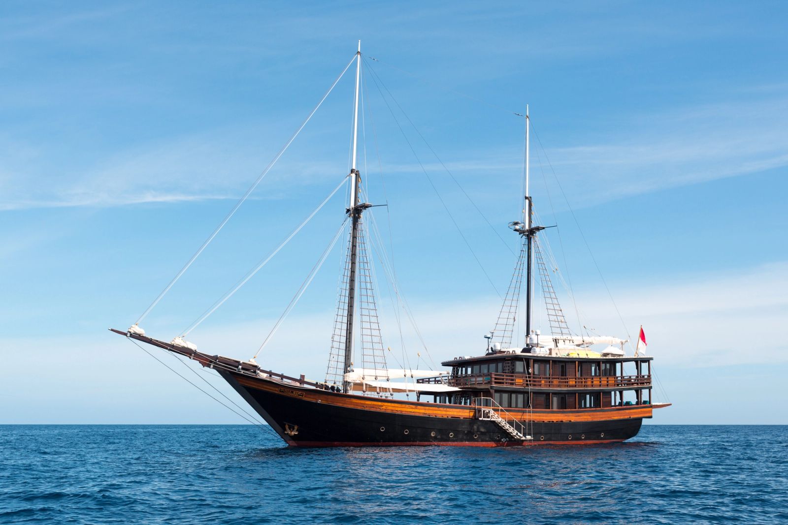 A phinisi at anchor on blue water