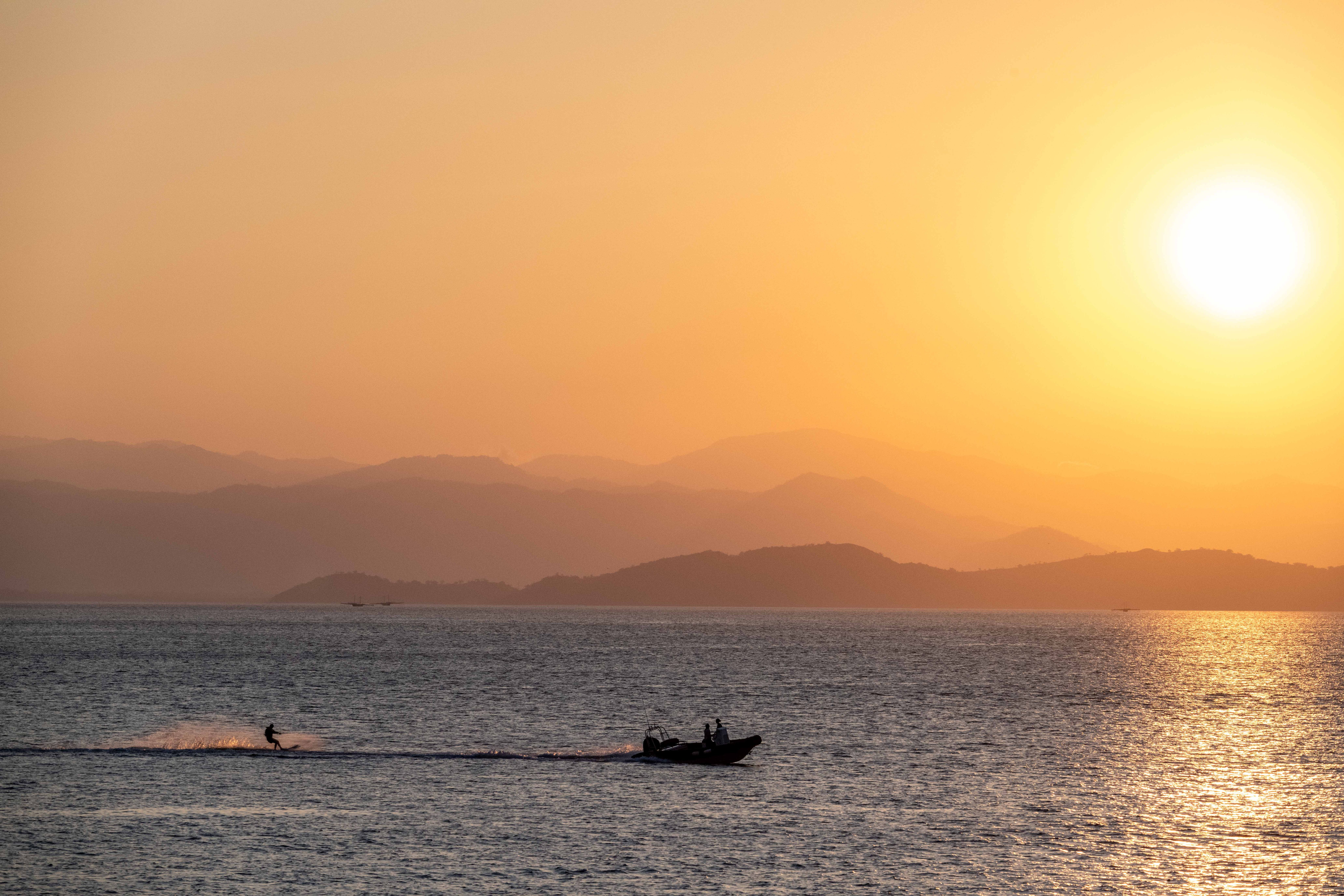 A guest rides a water toy off the stern of a charter yacht in Indonesia