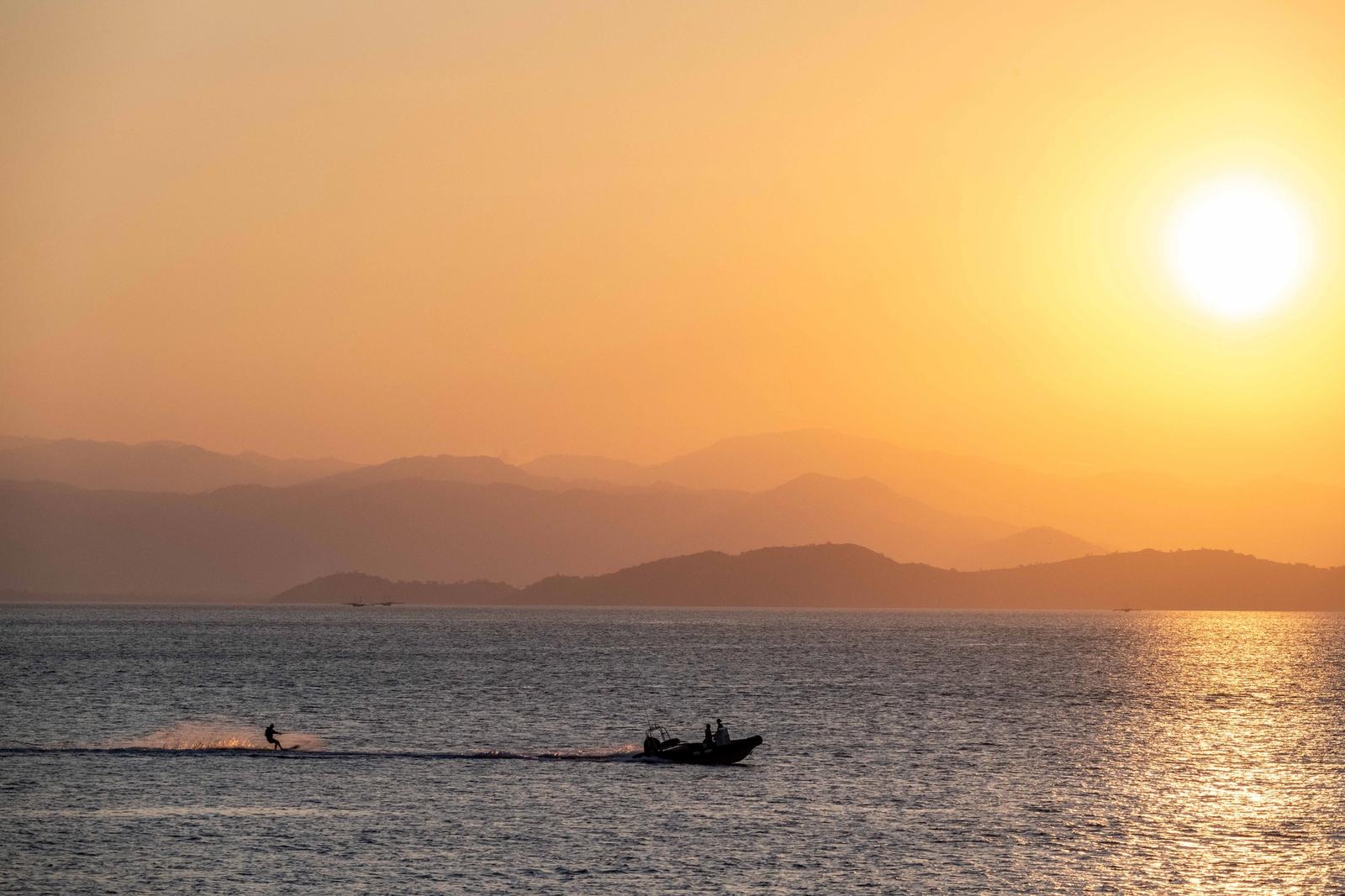 A guest rides a water toy off the stern of a charter yacht in Indonesia