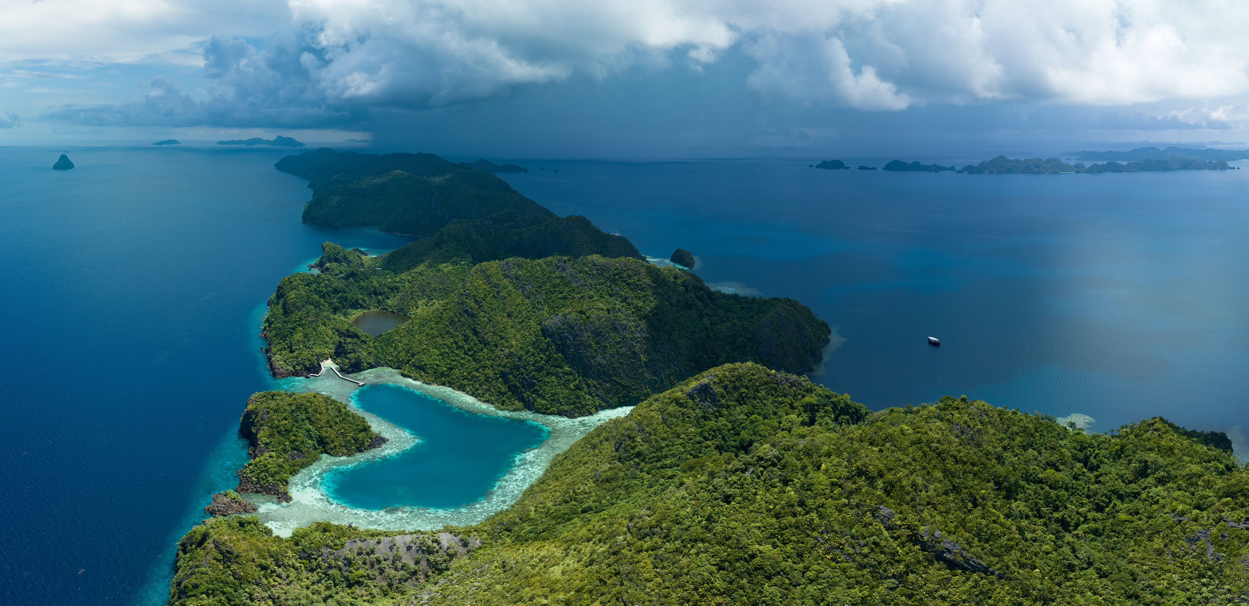 A heart-shaped lagoon is surrounded by dramatic limestone islands that rise from Raja Ampat's seascape in Misool. This remote part of Indonesia is known for its incredible marine biodiversity.