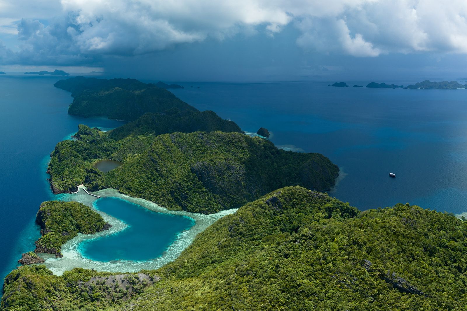 A heart-shaped lagoon is surrounded by dramatic limestone islands that rise from Raja Ampat's seascape in Misool. This remote part of Indonesia is known for its incredible marine biodiversity.