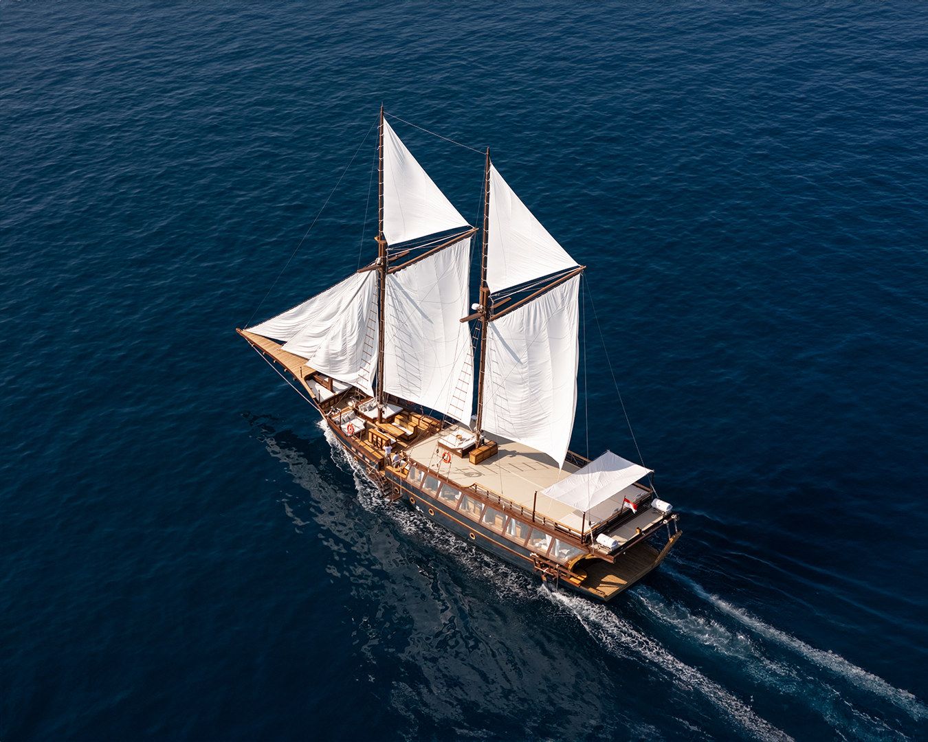 An aerial view of Sanya under full sail with a white wake.