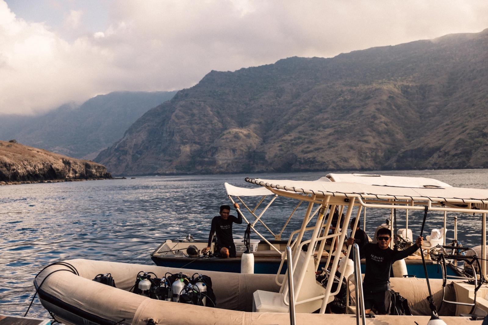 Dive crew ready a tender loaded with tanks below the hills of Komodo National Park