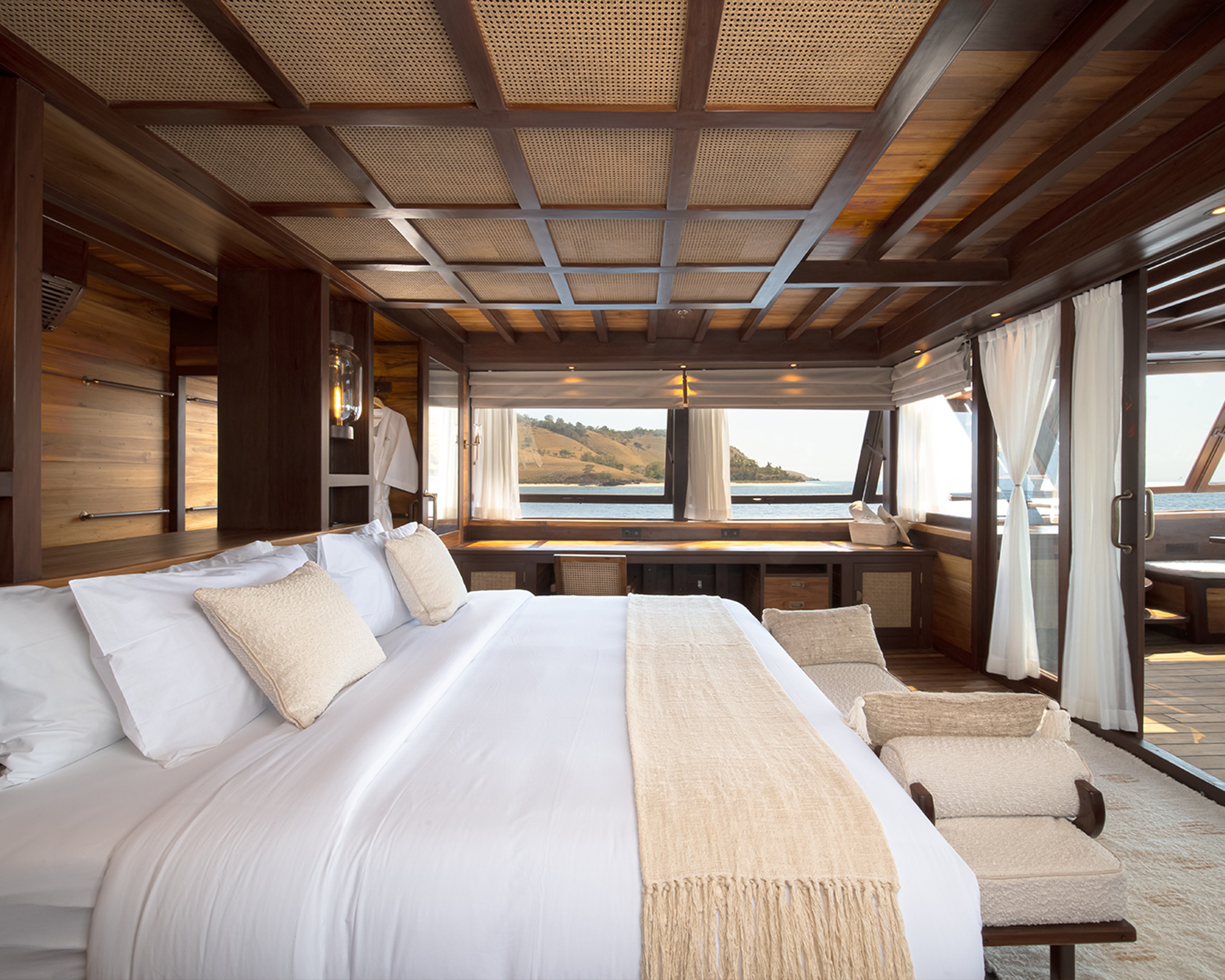 The master cabin on Sanya with a large bed, a daybed and windows on both sides.