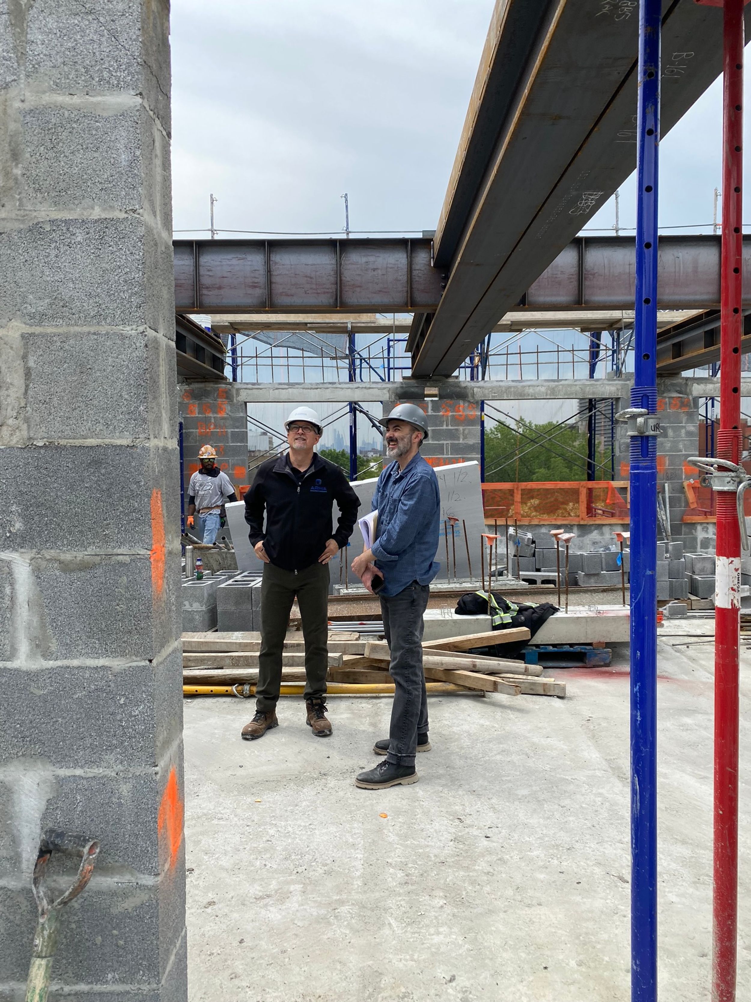 SGS Director of Construction Administration Sean Kennedy with project team member, with steel frame overhead.