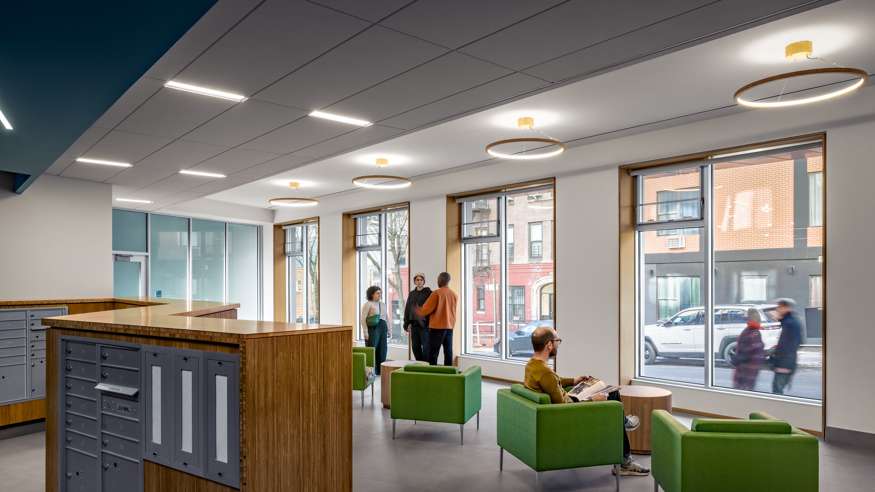 Lobby and mailboxes with chairs looking out onto the street