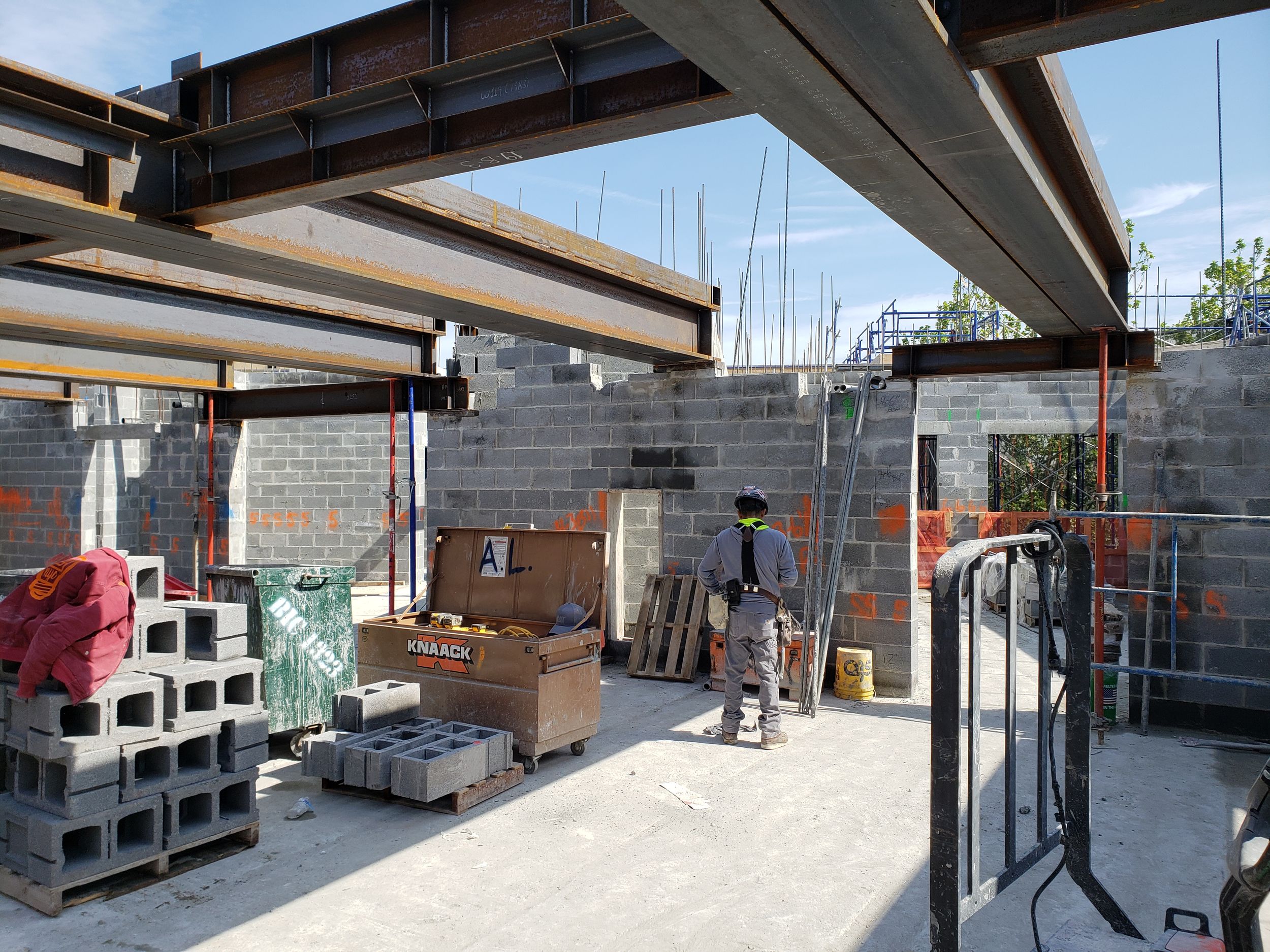 View of 8th floor steel frame and interior walls in the process of being constructed, with materials in foreground.