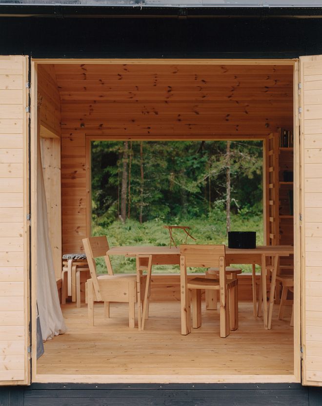 View from outside into the studio interior, with a dining table and chairs in the center