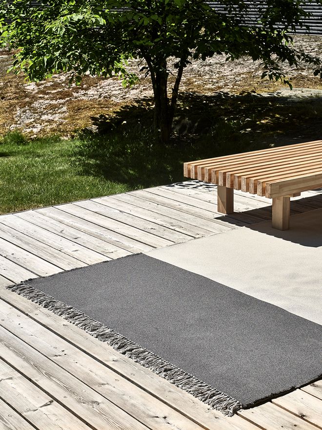 The Pond rug by Woodnotes on a terrace.