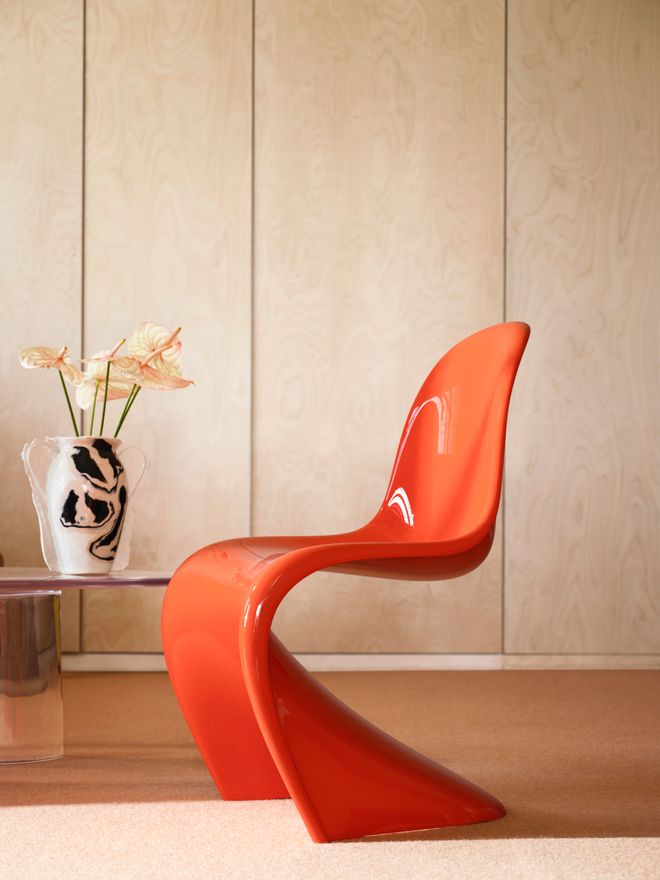 Glossy bright red Panton Chair by Verner Panton against a clean, minimalist background