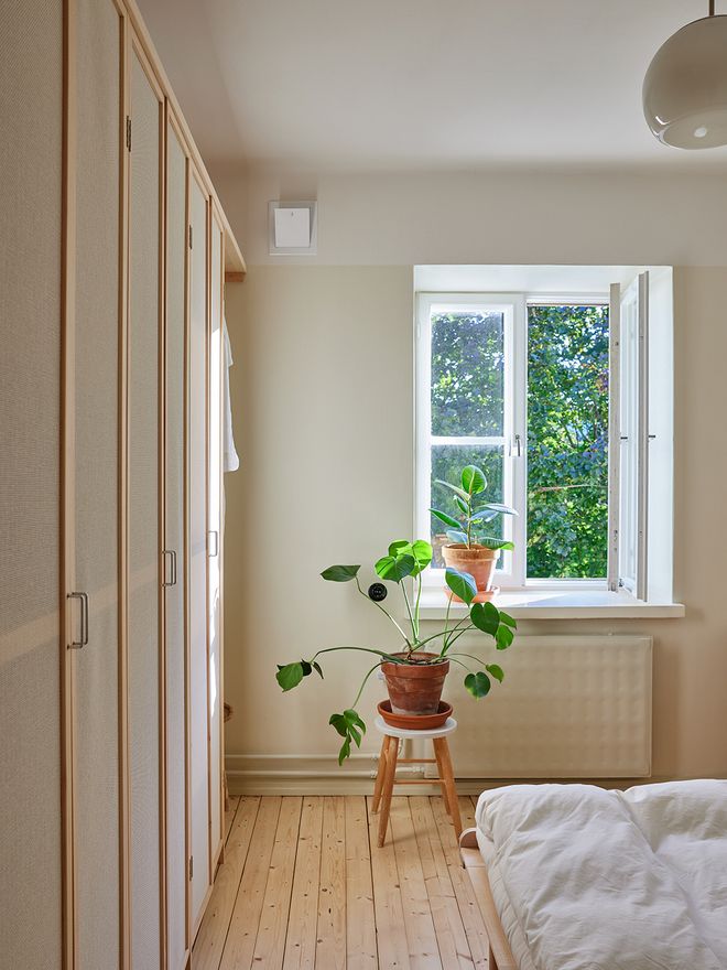A bedroom with cabinets and a window 