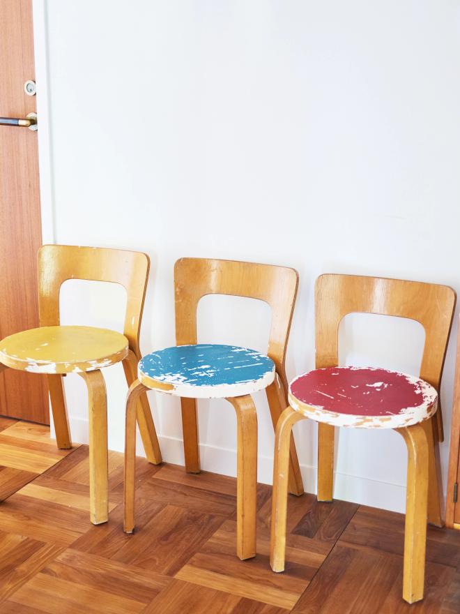 Vintage Artek chairs with yellow, blue, and red seats