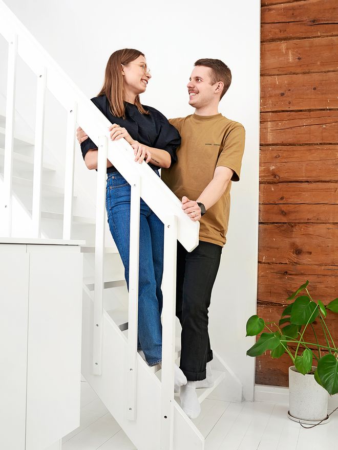 A portrait of a couple in front of an exposed log wall