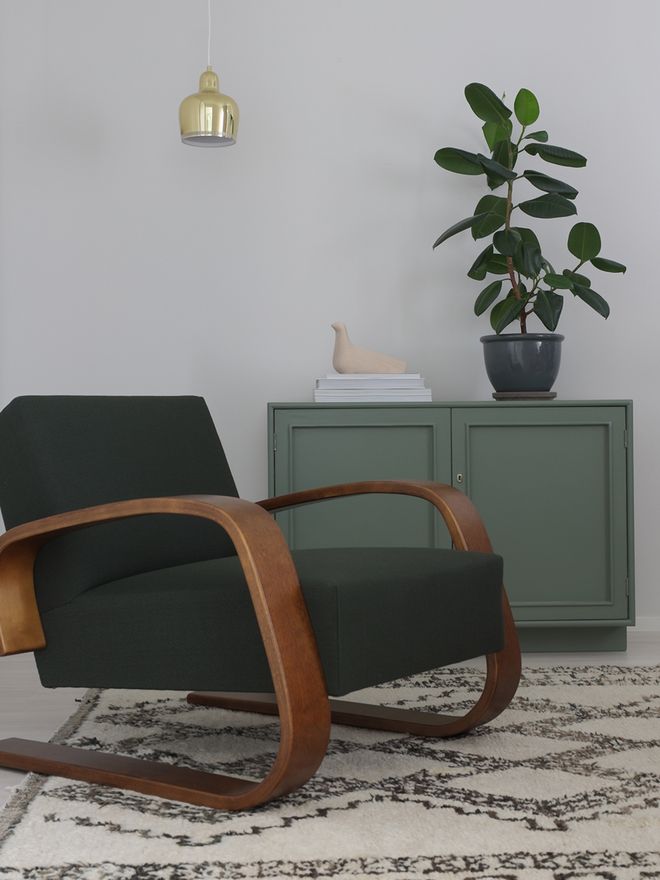 An image featuring Artek's Tank chair and Golden Bell pendant lamp as part od the living room decor.
