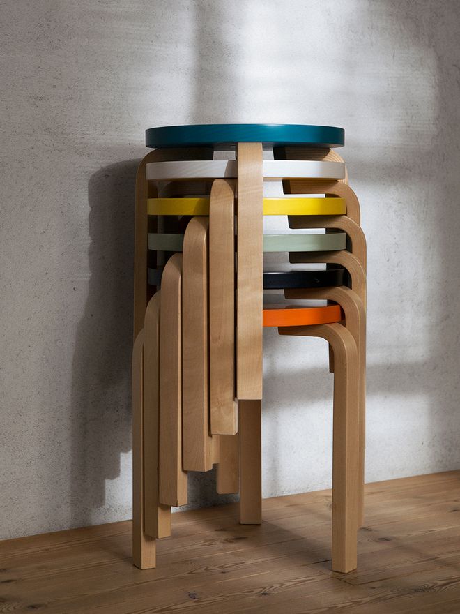 Artek's stool 60 stacked in a pile in different colors.