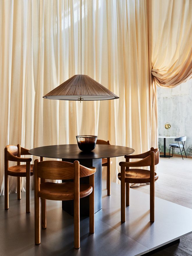 An image featuring GUBI's Paavo Tynell's 1967 lamp as part of the dining room interior.