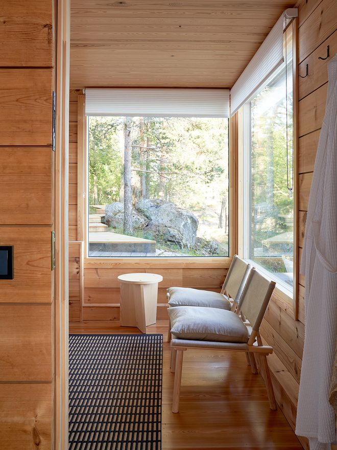 The sauna dressing room, with a Woodnotes New York rug, Nikari chairs and a small table, and roller blinds.