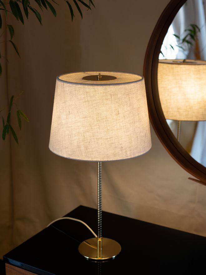 An image featuring GUBI's Paavo Tynell's 9205 table lamp as part of the living room interior.