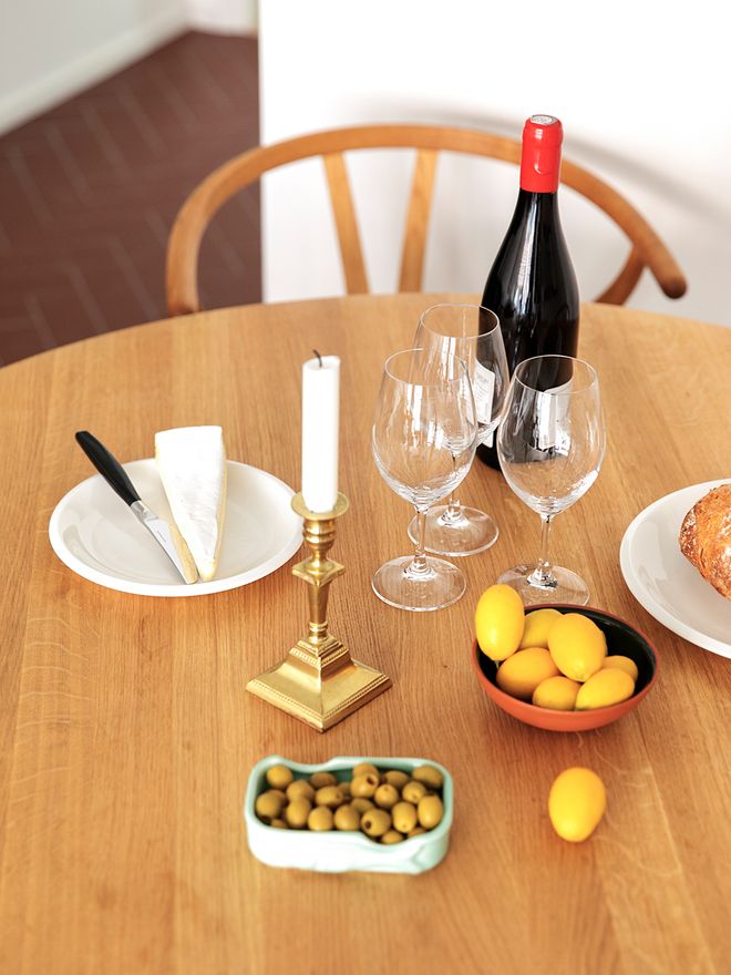 A dining table with a wine bottle and olives